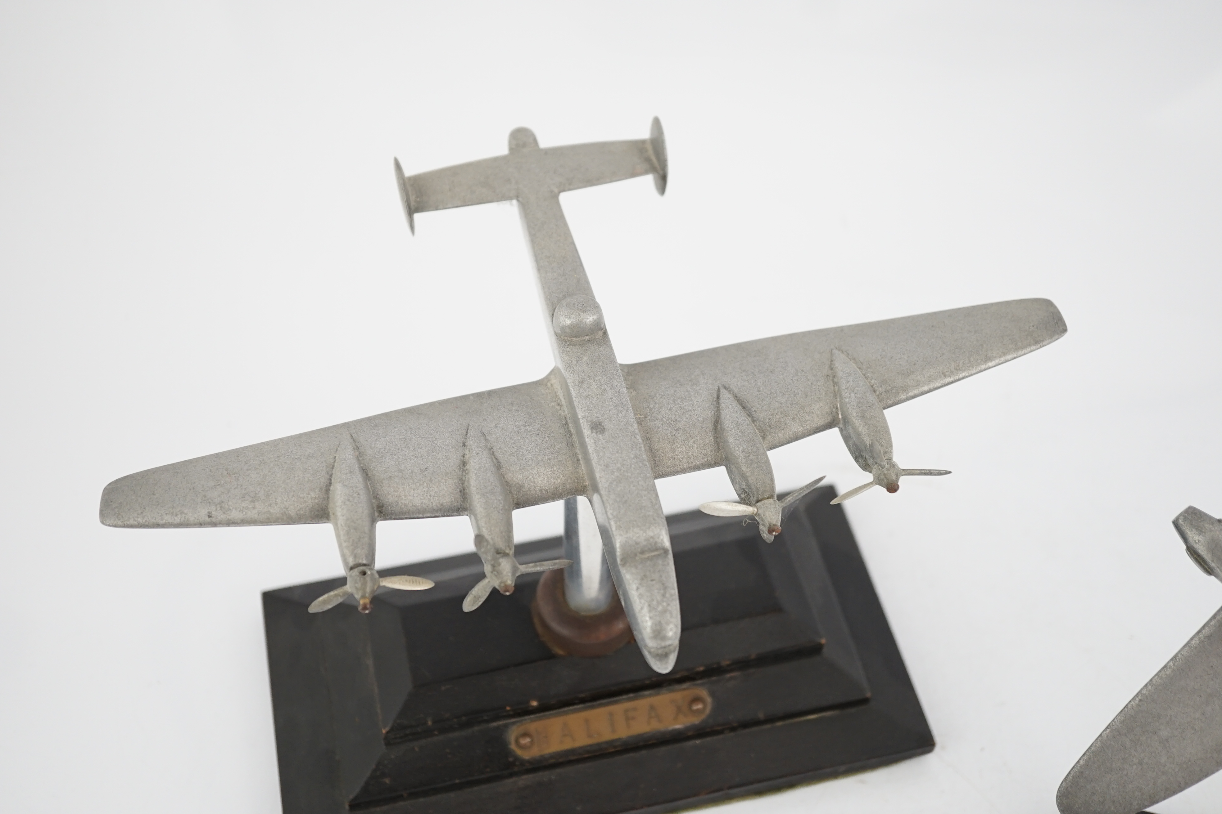 Two cast aluminium military aircraft models mounted on stepped wooden bases; a Halifax bomber, wingspan 30.5cm, and a Hawker Hurricane, wingspan 18cm